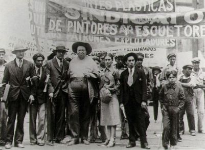 Frida Kahlo e Diego Rivera em manifestação do dia dos/as trabalhadores/as. Foto: Tina Modotti, 1929.